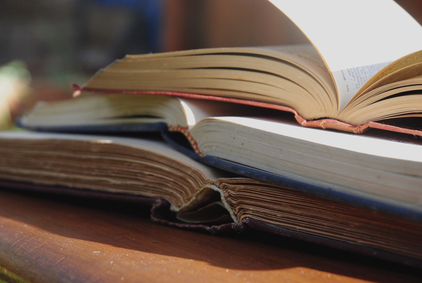 Стопка раскрытых старых книг на деревянном столе